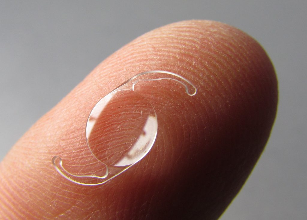 Een kunstlens op een vingertop: de lens is opvouwbaar en past door een sneetje van enkele millimeters